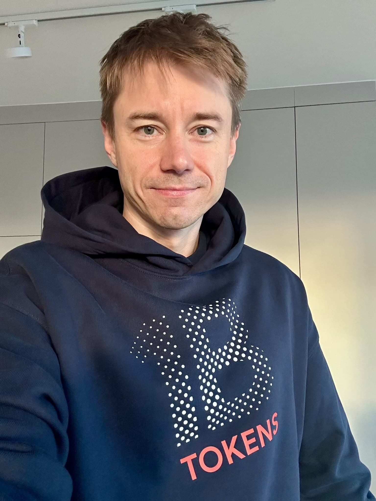 Michal Juhas wearing a navy 1B Tokens hoodie